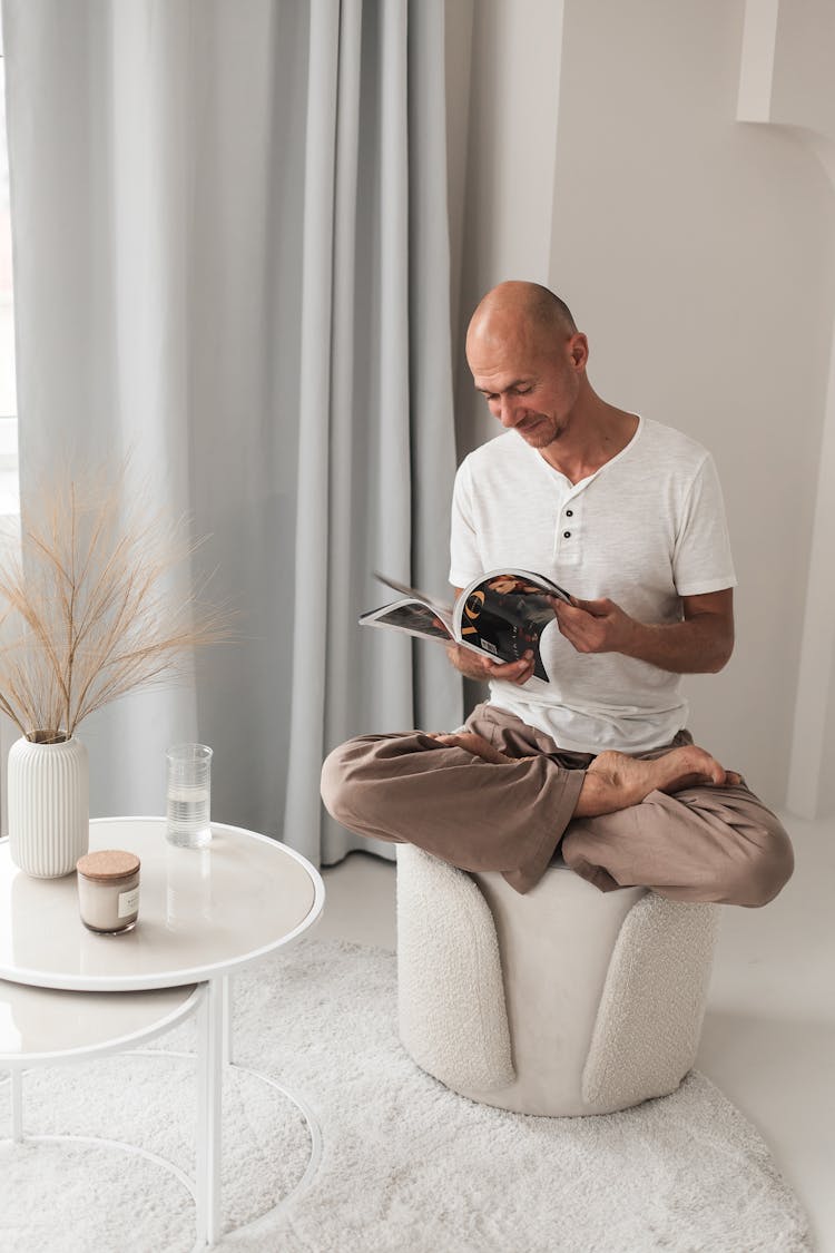 Bald Man Reading Magazine In Room