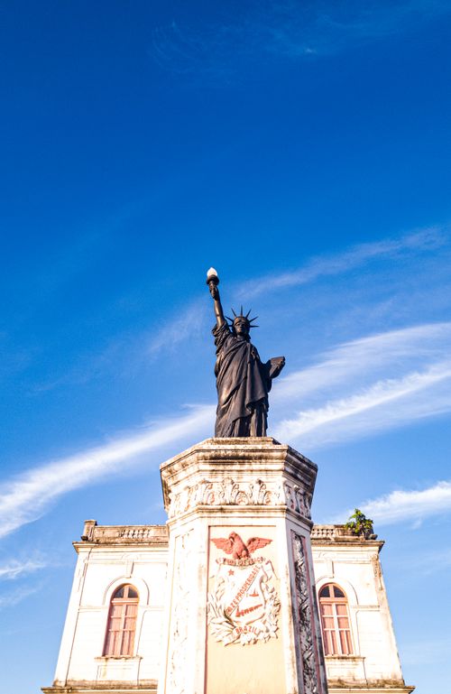 Free A replica of the Statue of Liberty stands tall against a vibrant blue sky. Stock Photo