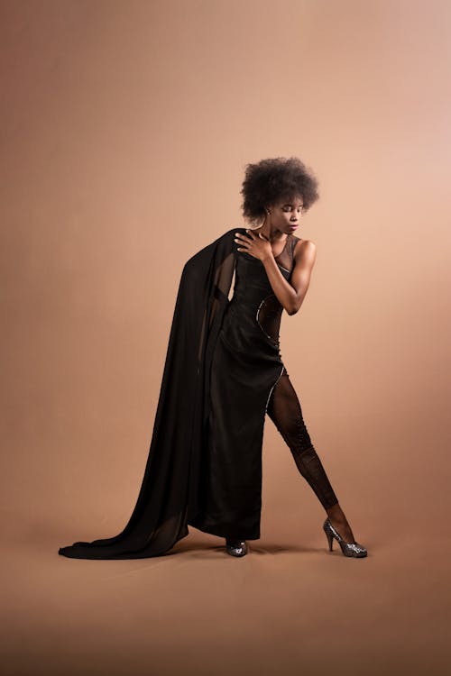 Darmowe zdjęcie z galerii z brązowe tło, czarna kobieta, czarna sukienka
