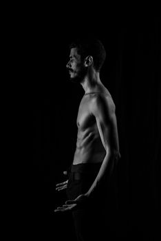 Artistic black and white portrait of a shirtless man in profile pose.