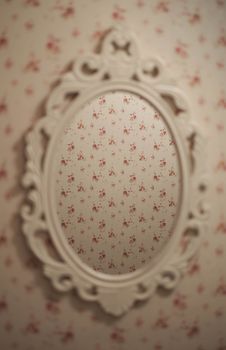 An elegant vintage ornate mirror reflecting floral patterned wallpaper, creating a seamless and artistic still life composition.