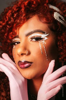 A striking portrait of a woman with artistic makeup, wearing gloves and pearls.