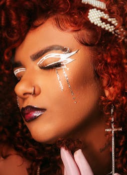 Close-up portrait featuring bold creative makeup with jewelry accents, showcasing artistic styling.