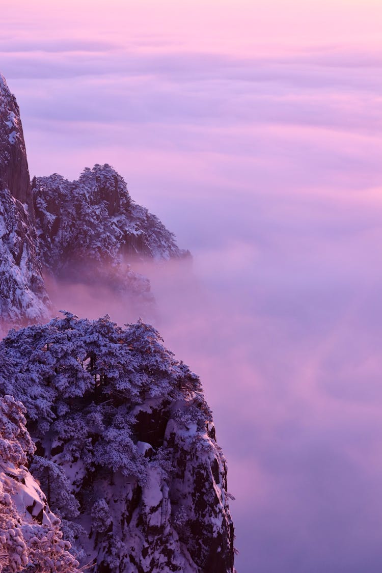 Snowcapped Mountains Above The Clouds At Sunset 