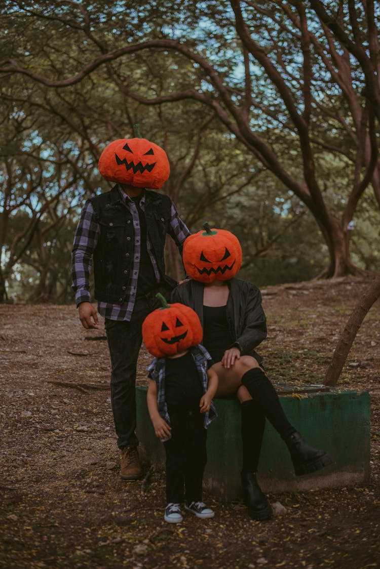 Family Wearing Pumpkin Heads Posing Outdoors