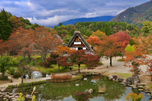 Scenic autumn view of a Gassho-zukuri house surrounded by colorful foliage in Shirakawa-go, Japan.