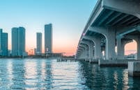 迈阿密海滩的天际线景色令人惊叹，日落时一座桥倒映在水面上