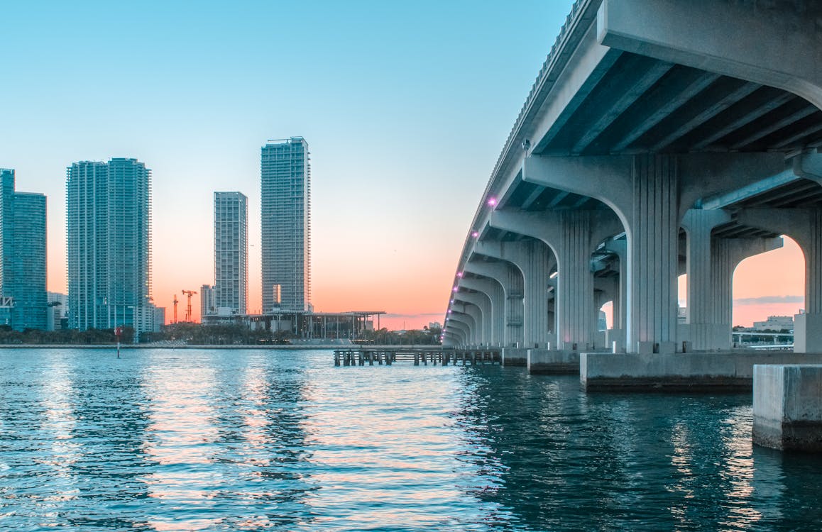 Body of Water Under Bridge Near Buildings