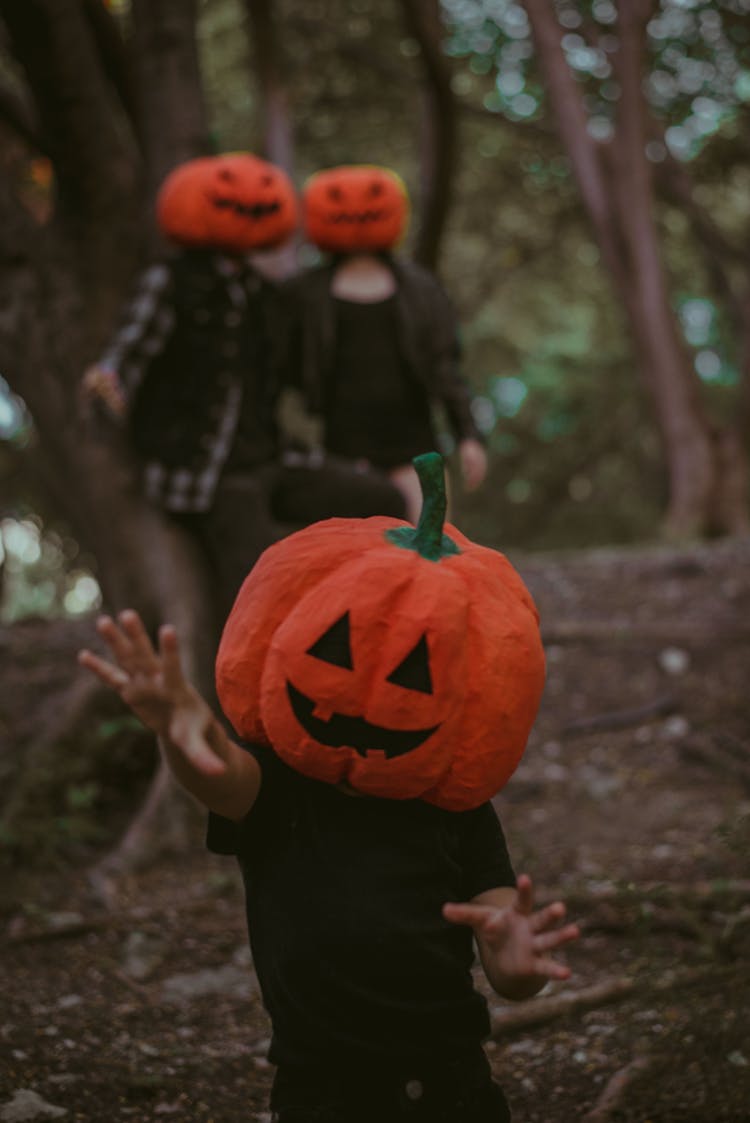 Parents And A Little Child With Pumpkins On Their Heads 