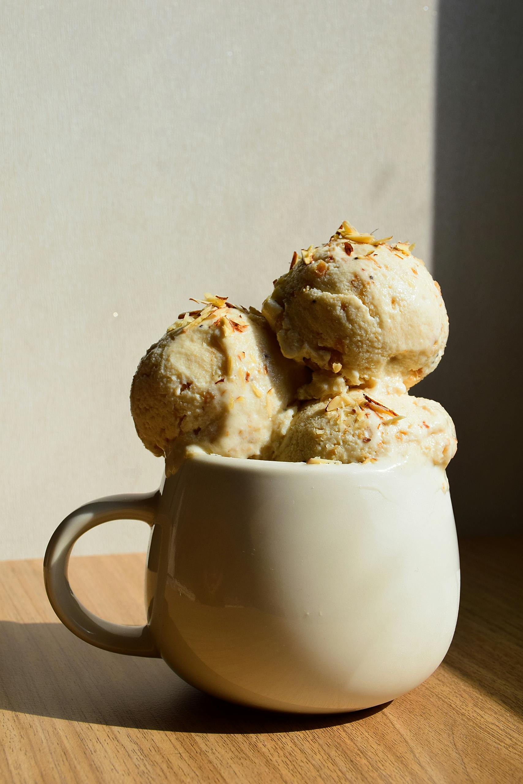 Delicious ice cream in a ceramic mug on a wooden table, perfect for dessert lovers.