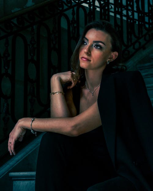 Photo of an Elegant Woman Sitting on a Staircase