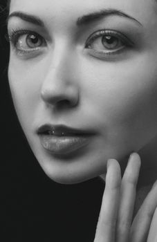 Intimate close-up portrait of a woman in black and white, highlighting facial features.