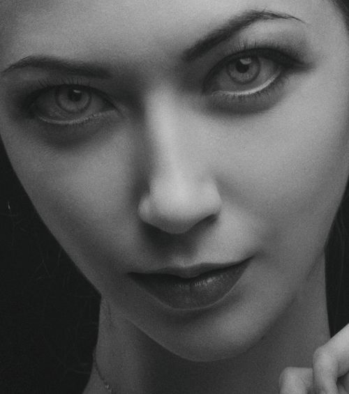 Free Artistic black and white close-up portrait of a young woman with striking eyes. Stock Photo