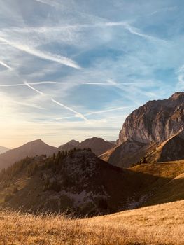 Stunning mountain peaks under a clear blue sky with scenic hills and vibrant sunlight.