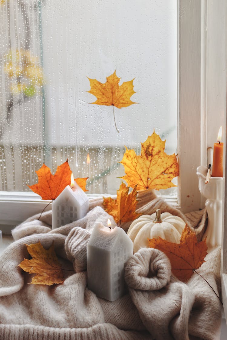 Photo Of Candles, Pumpkin And Yellow Leaves In Cozy Interior