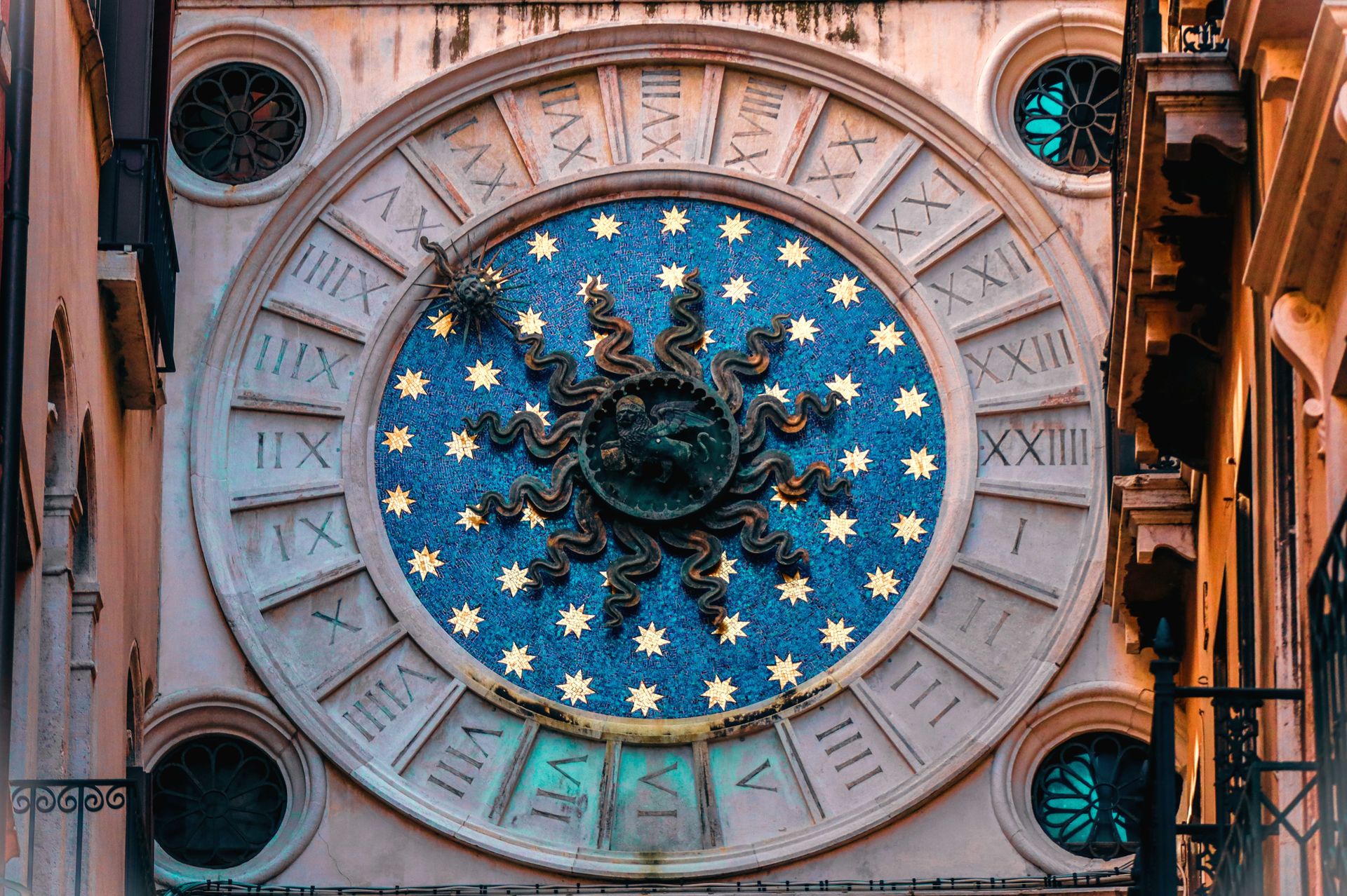 Ornate Venetian clock tower featuring zodiac signs and Roman numerals in Venice, Italy.