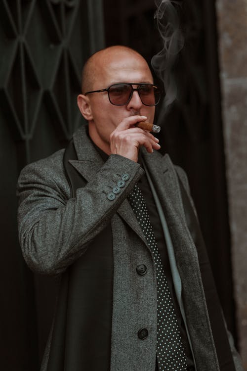 A Man in a Black Coat Smoking a Cigar · Free Stock Photo