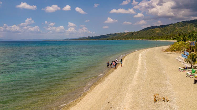 Photo Of Tropical Coastline With People On A Beach