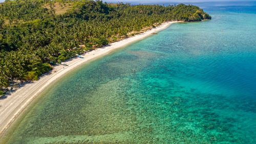 Free A breathtaking aerial view of a tropical beach with lush greenery and turquoise waters. Stock Photo