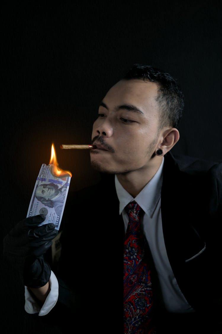 Man Lighting His Cigarette With Burning Bank Note