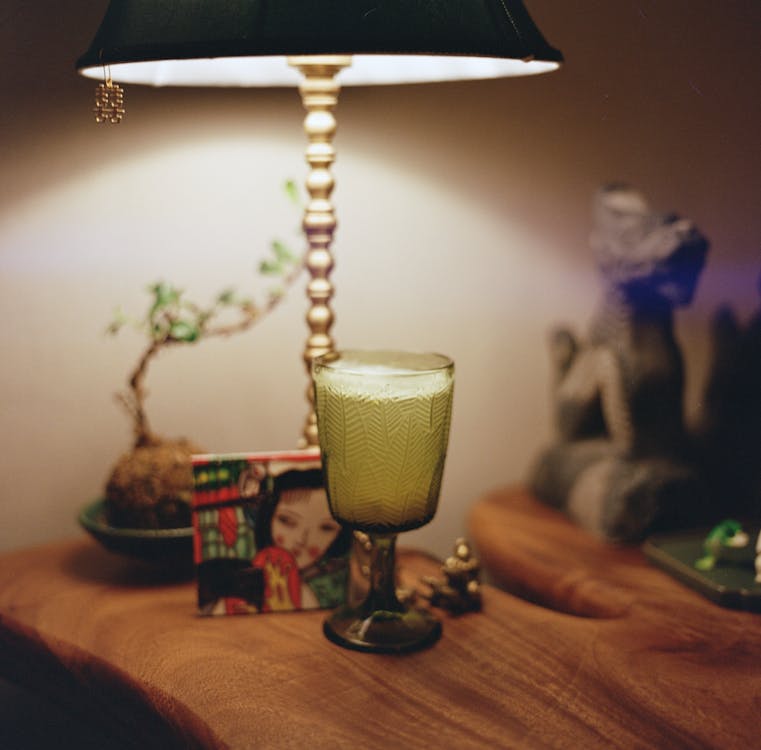 Photo of a Full Green Glass with Lamp and Trinkets