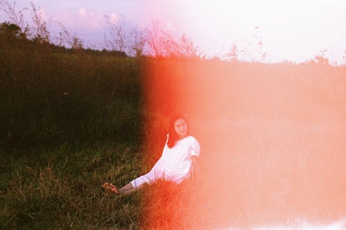 Woman Sitting on Grass with Straight Legs