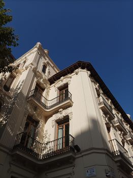 Low angle view of a historical elegant building with ornate details against a clear blue sky.