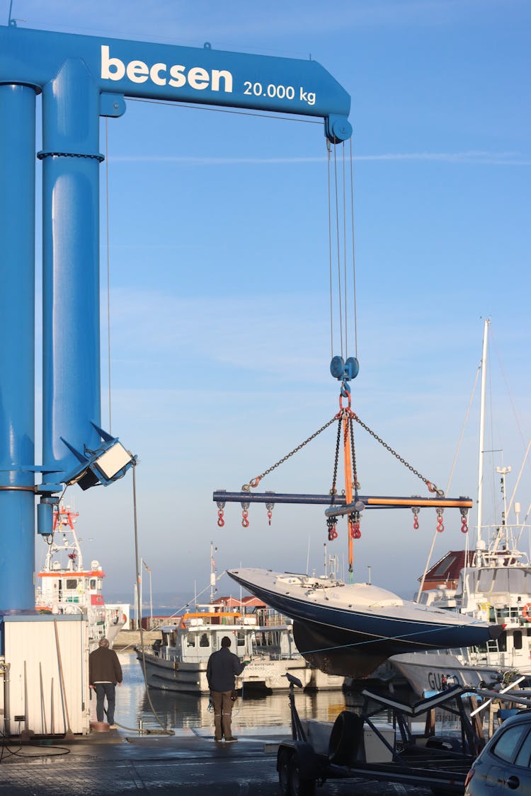 Photo Of A Crane Lifting A Boat In A Harbor