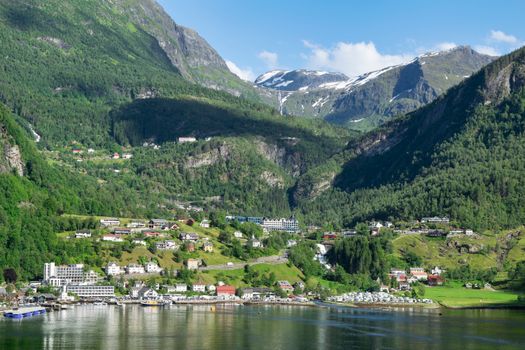Charming town nestled in lush, green mountains by a serene lake.