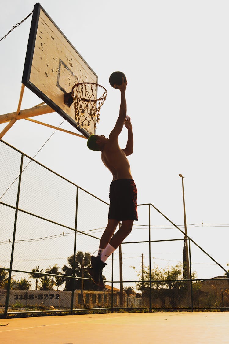 Man Throwing Ball Into Basket