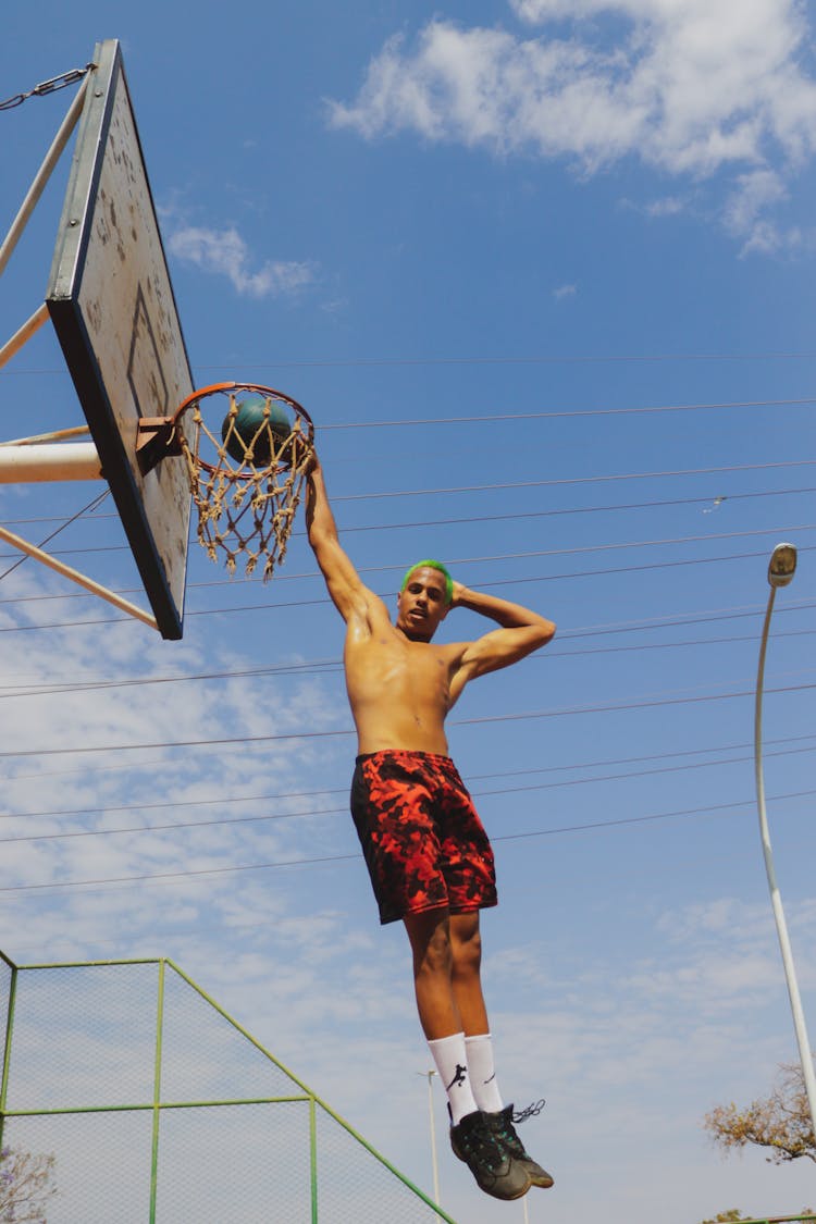 Funny Photo Of Basketball Player Jumping To Basket And Posing 