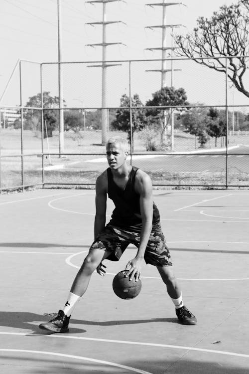 Black and White Photo of Man Playing Basketball