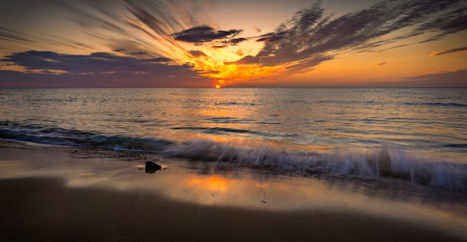 A mesmerizing sunset with vibrant colors reflecting on the peaceful ocean waves.