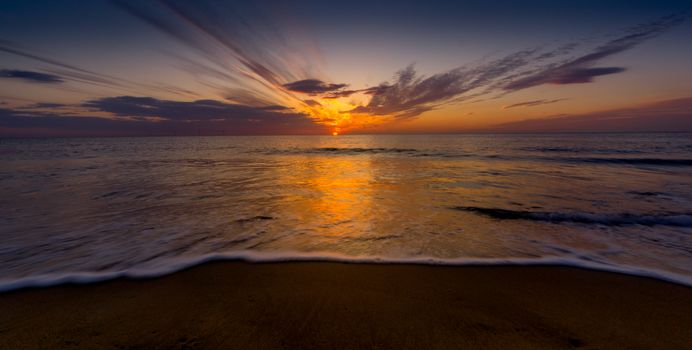 Breathtaking ocean sunset view with golden sky reflecting on water.