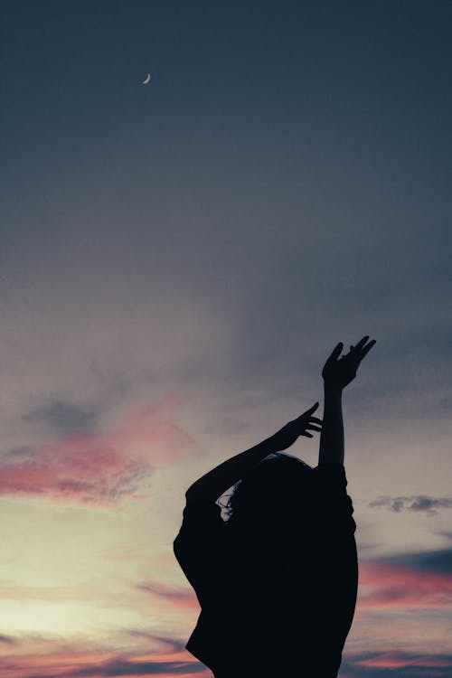 Silhouette of Person Raising Her Hands