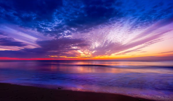 A breathtaking sunset over the tranquil ocean with vibrant colors and dramatic clouds.