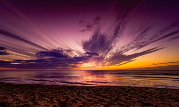 Purple and orange sky over calm sea at sunset, perfect serene escape.