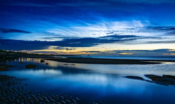 A peaceful twilight scene of a calm beach with reflection and blue skies.