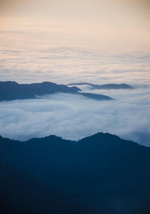 Free A breathtaking mountain landscape with peaks rising above a vast sea of clouds at sunrise. Stock Photo