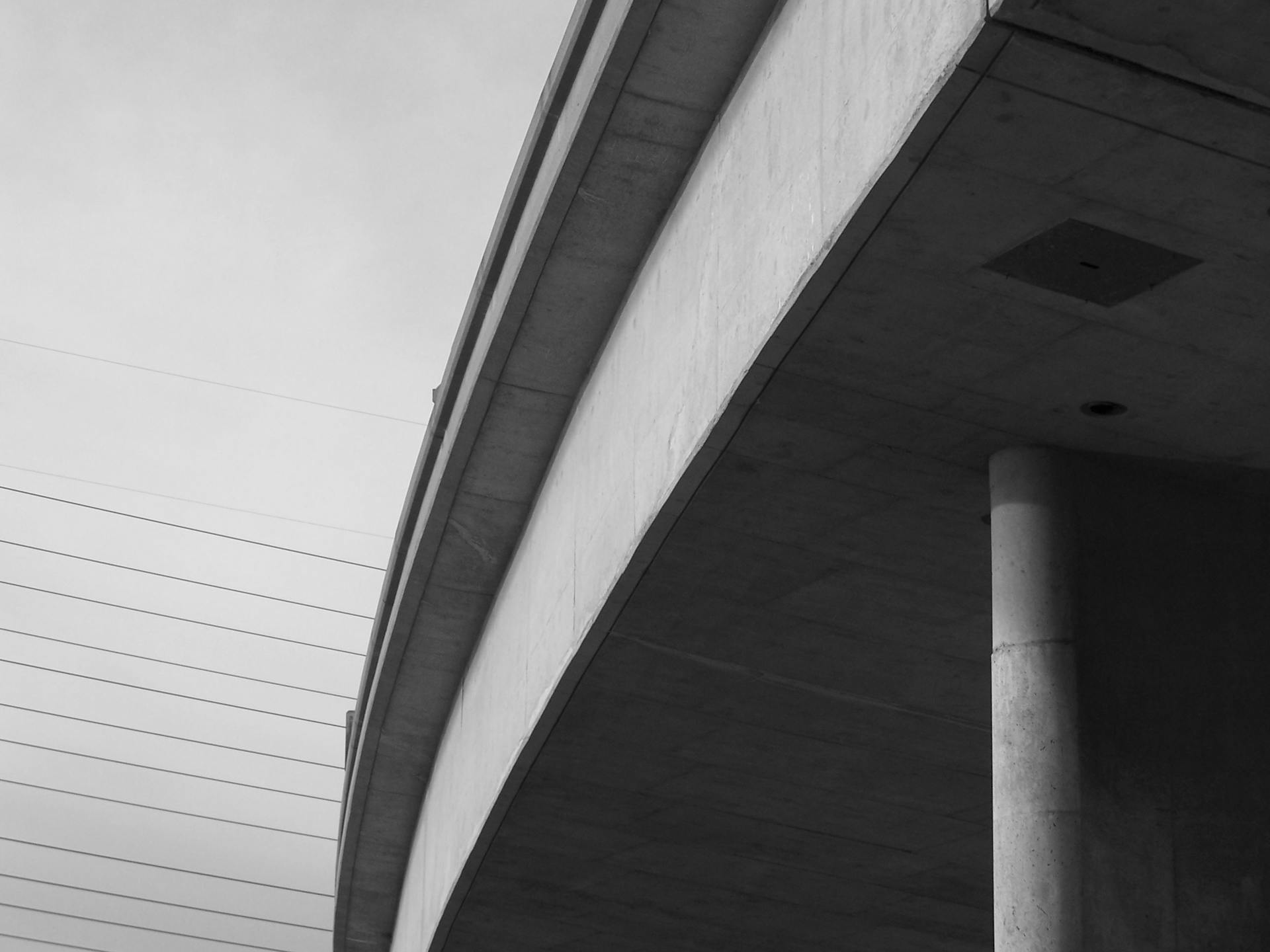 A black-and-white photo of a concrete overpass in Long Beach, CA, showcasing its architectural structure.