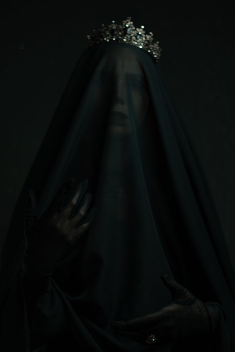 Mysterious woman shrouded in a black veil, adorned with a sparkling crown.