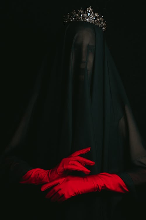 A Person in Black Veil Wearing Red Gloves