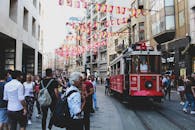 在土耳其卡拉泰节日的旗帜下，有轨电车和行人构成了充满活力的街头生活