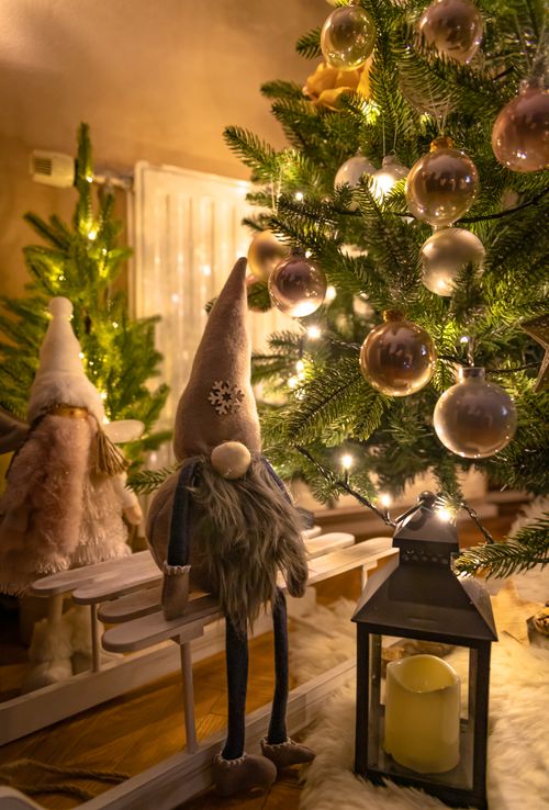 Free Warm festive setting featuring a Christmas tree with ornaments and a lantern. Stock Photo