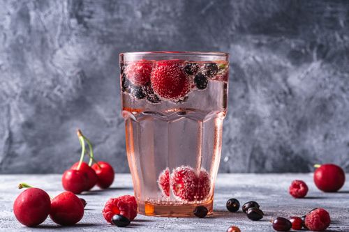 Free Glass of sparkling water with mixed berries for a refreshing and healthy beverage option. Stock Photo