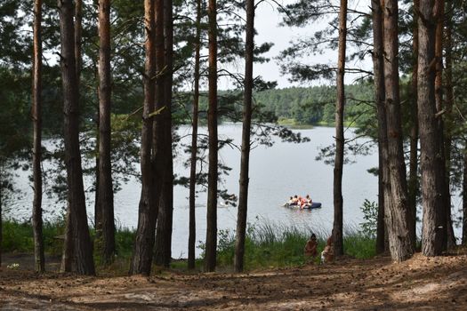 A serene lakeside view in Rivne, Ukraine, with people enjoying nature from a raft.