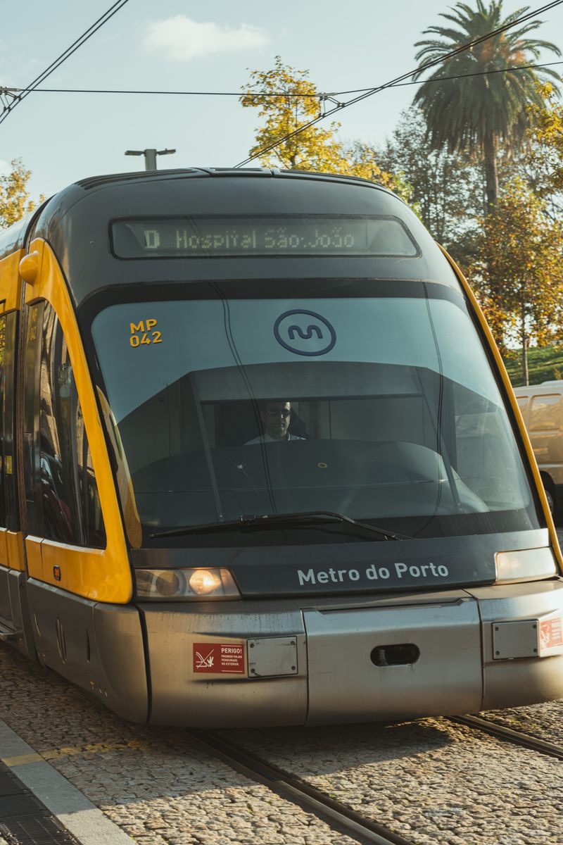 A Metro do Porto train on its route to Hospital São João in a sunny setting.