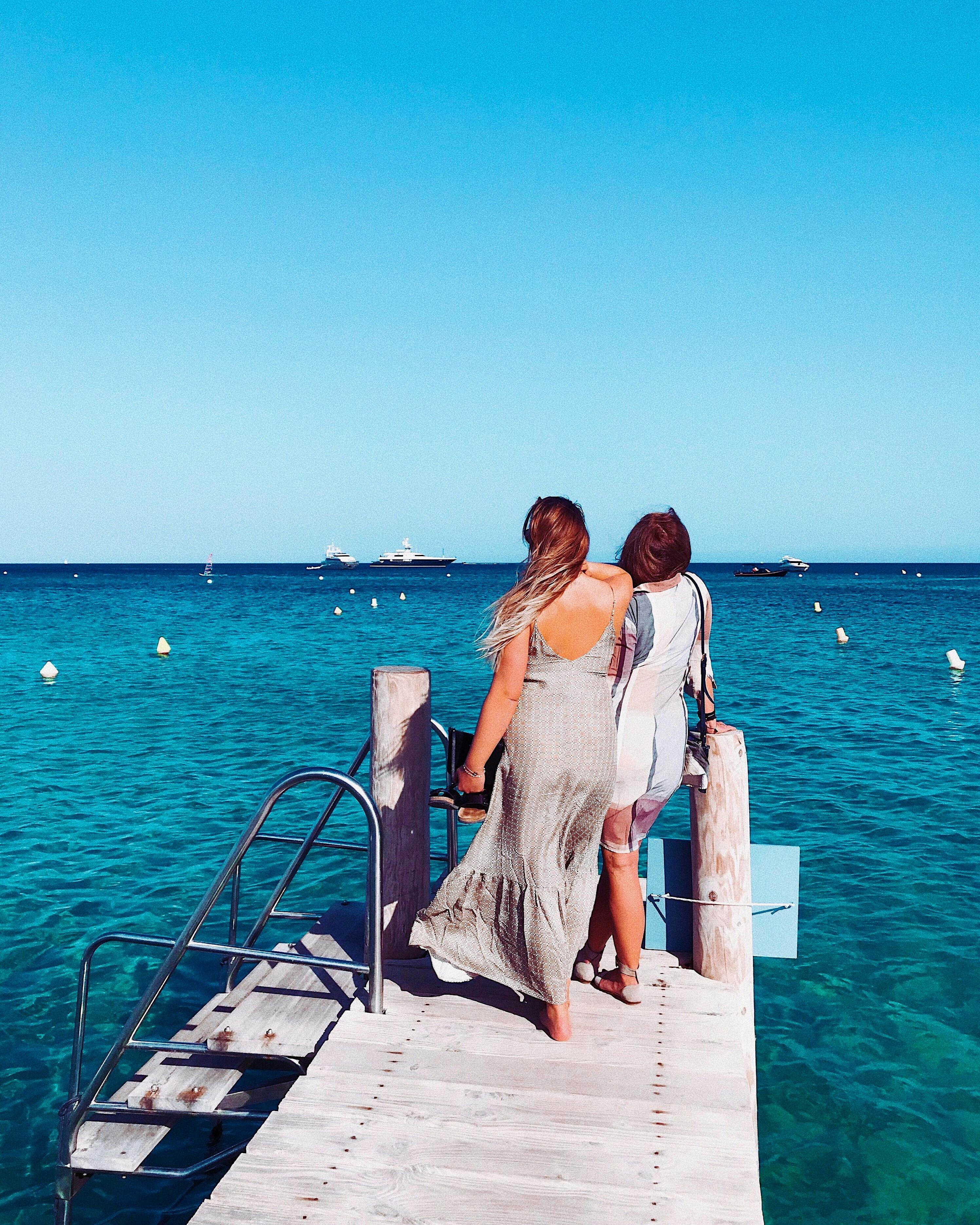 在法国海滨码头，两名女子正享受着阳光明媚的一天，非常适合休闲放松