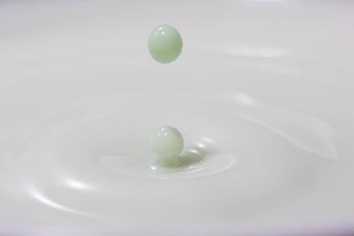Closeup of green colored bouncing milk droplet