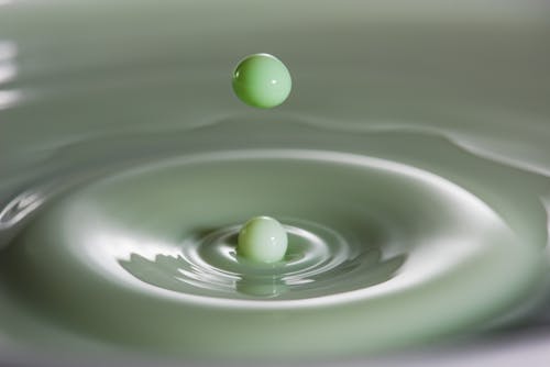 Closeup of green colored bouncing milk droplet